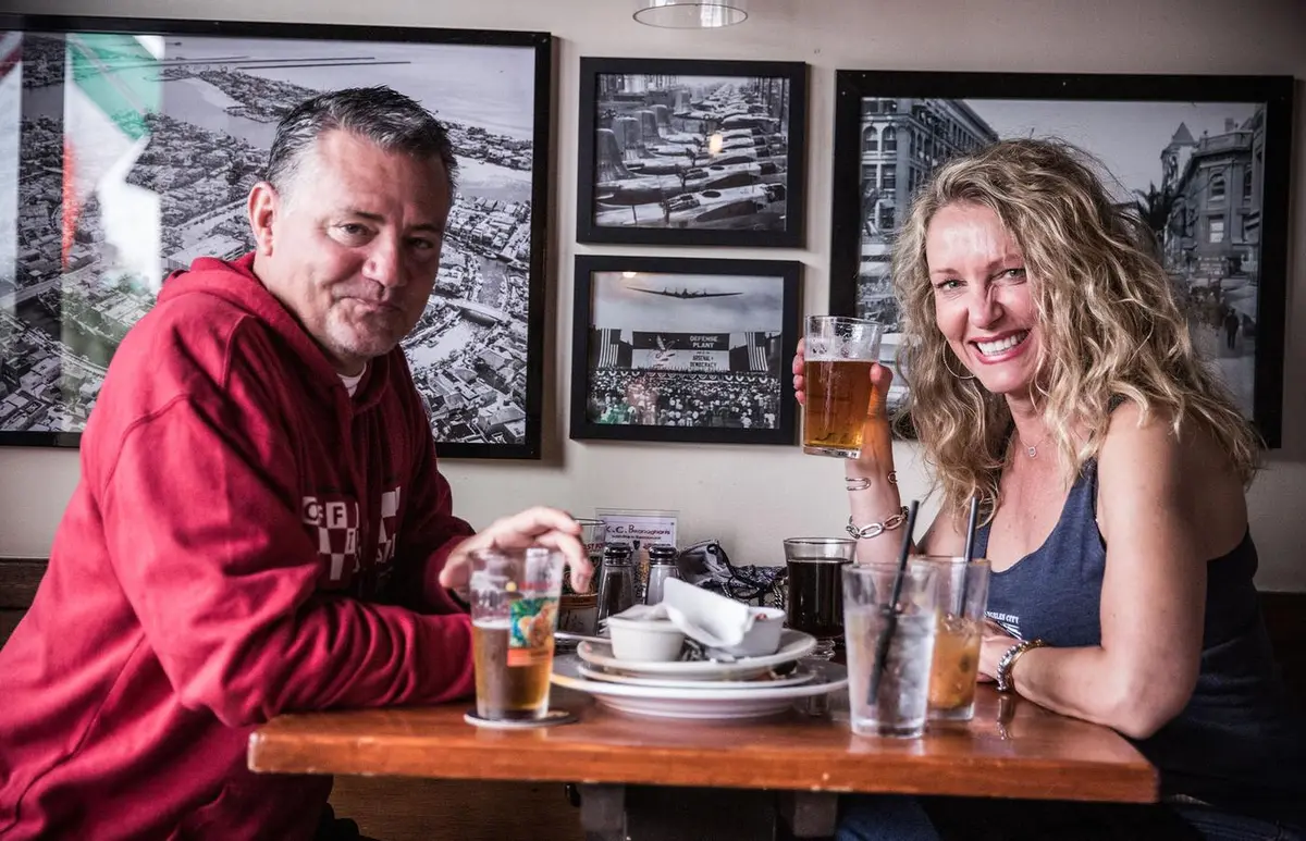 Regulars enjoying pints and dinner beneath photos of old Long Beach