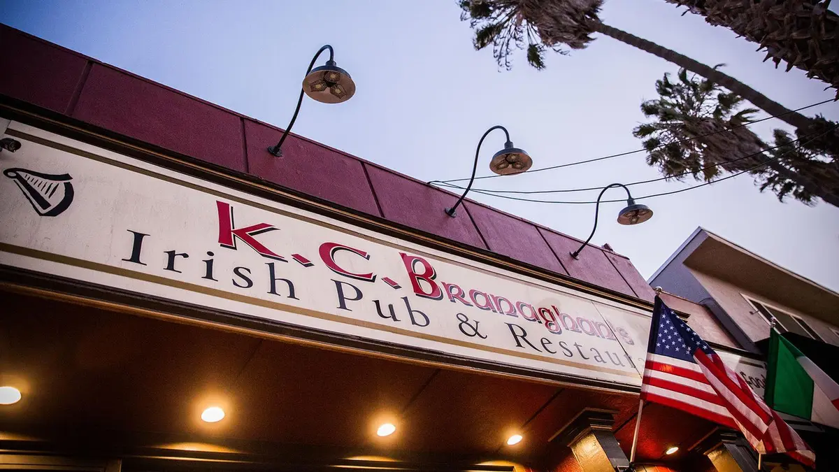 K.C. Branaghan's storefront sign lit warmly at dusk on East Second Street