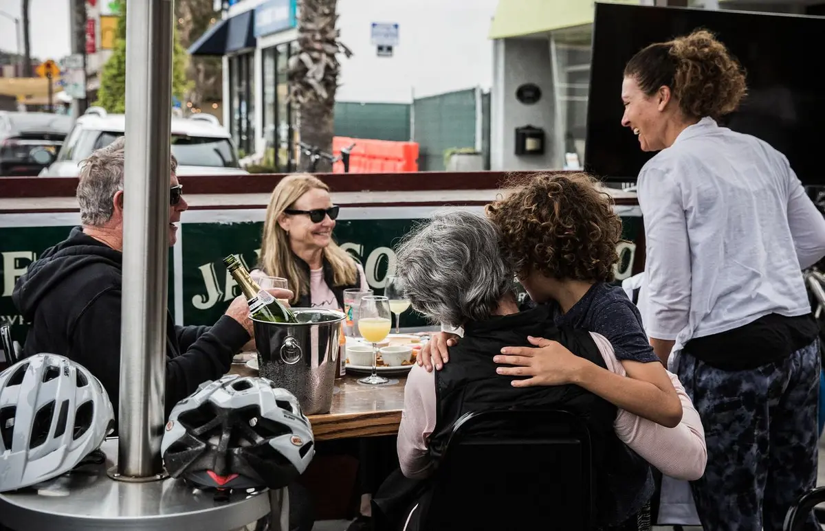 Neighbors greeting each other at the patio tables